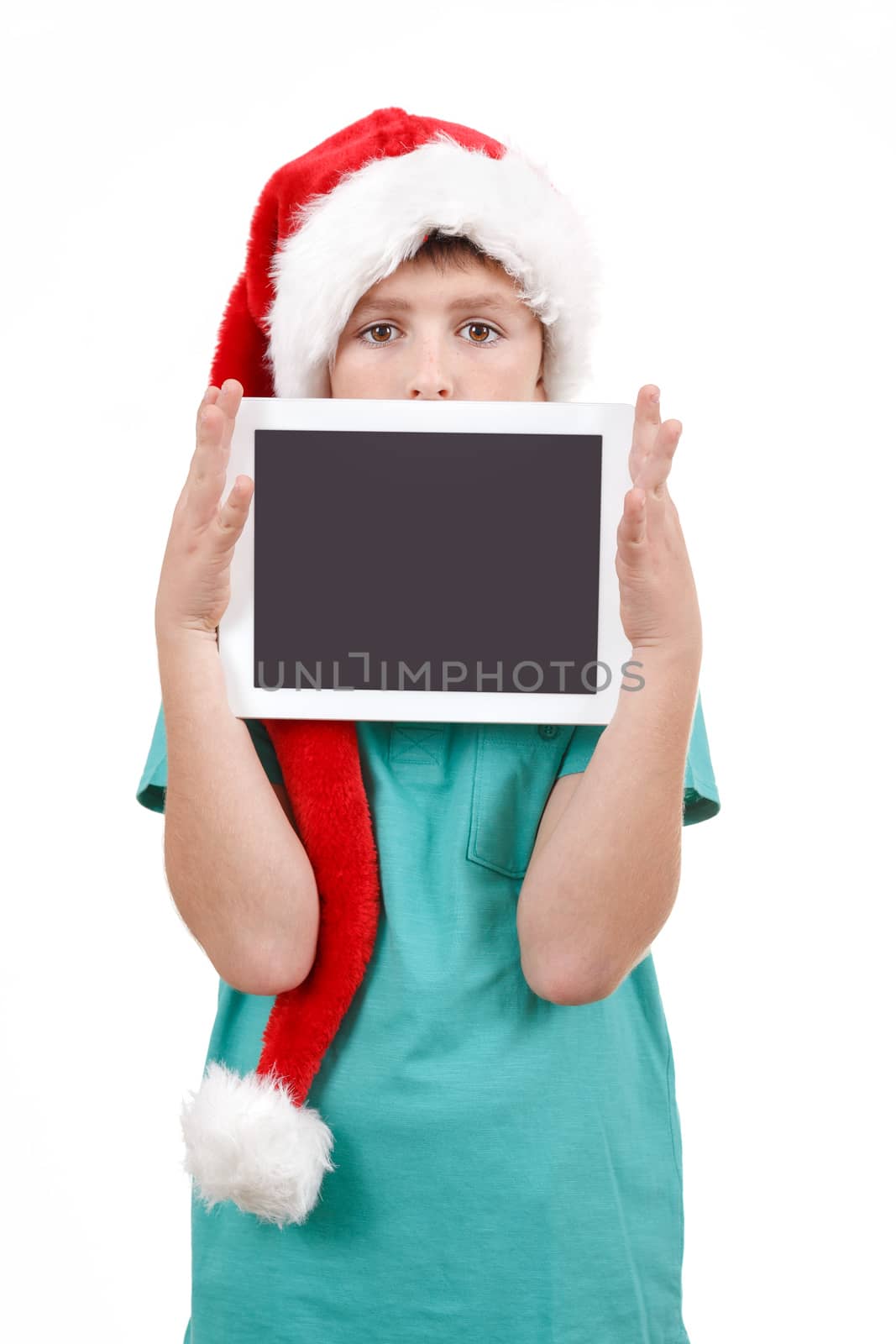 teenage boy with santa claus hat isolated on white and showing his new digital tablet 