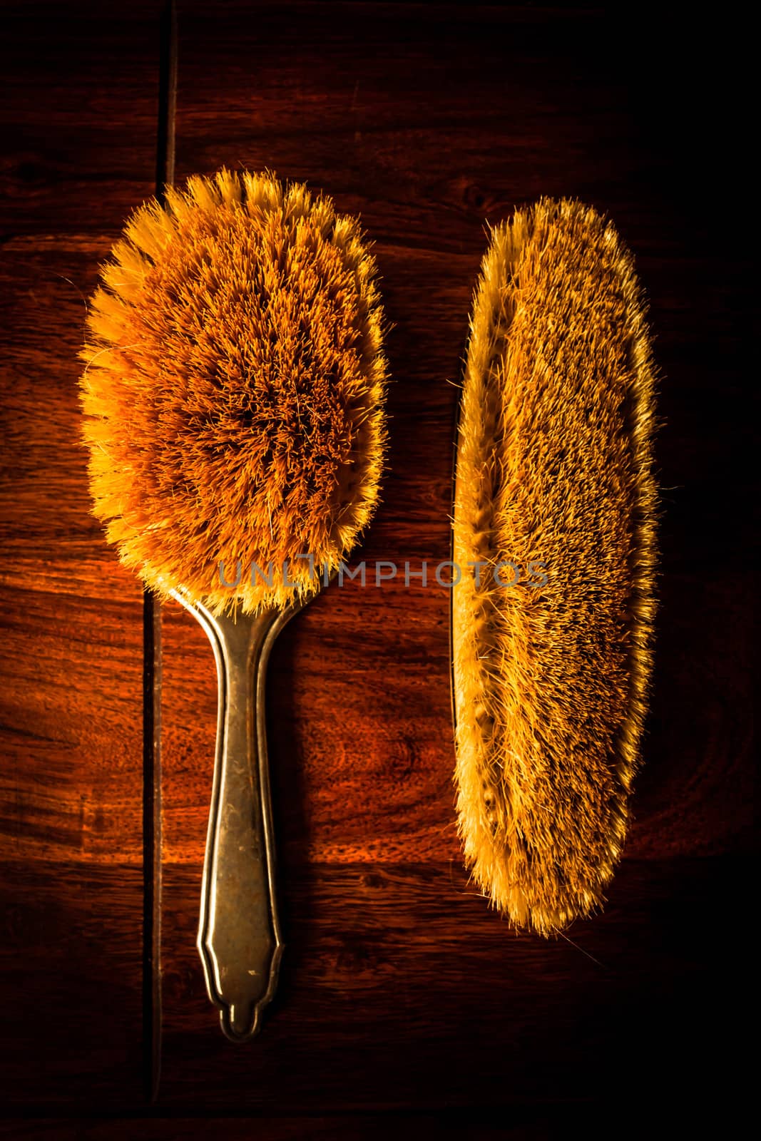 A pair of vintage hairbrushes on solid dark wood