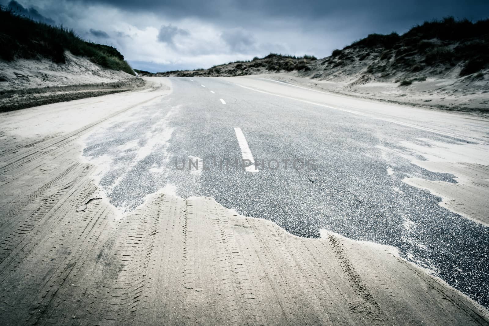 Sandy road surrounded by dunes and reed