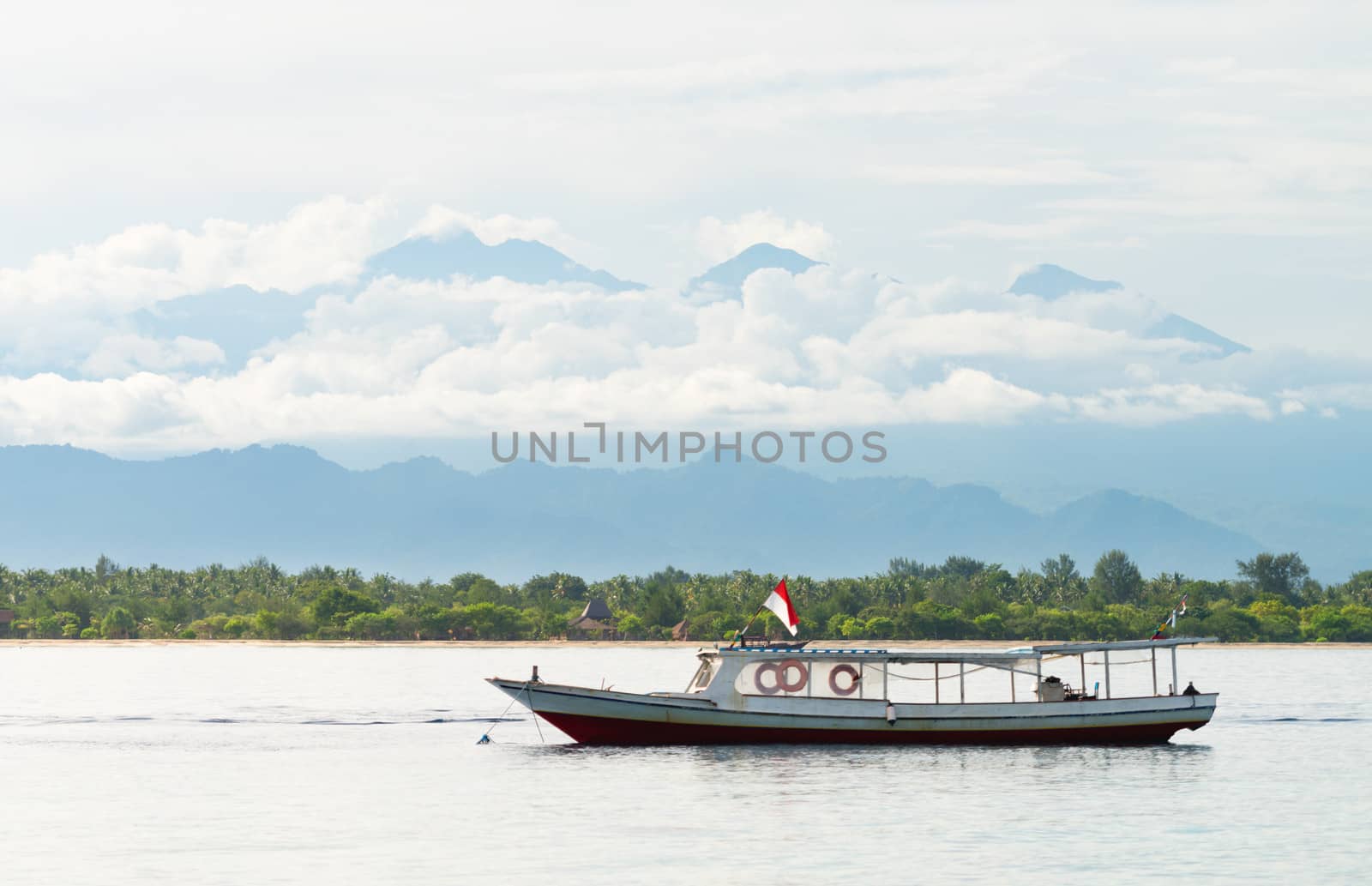 Long wooden boat on the sea with mountains on background
