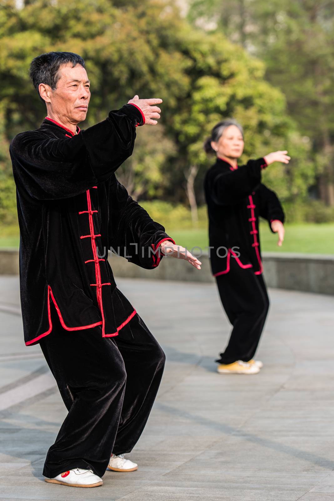 Shanghai, China - April 7, 2013: people exercising tai chi with traditional costume in gucheng park in the city of Shanghai in China on april 7th, 2013
