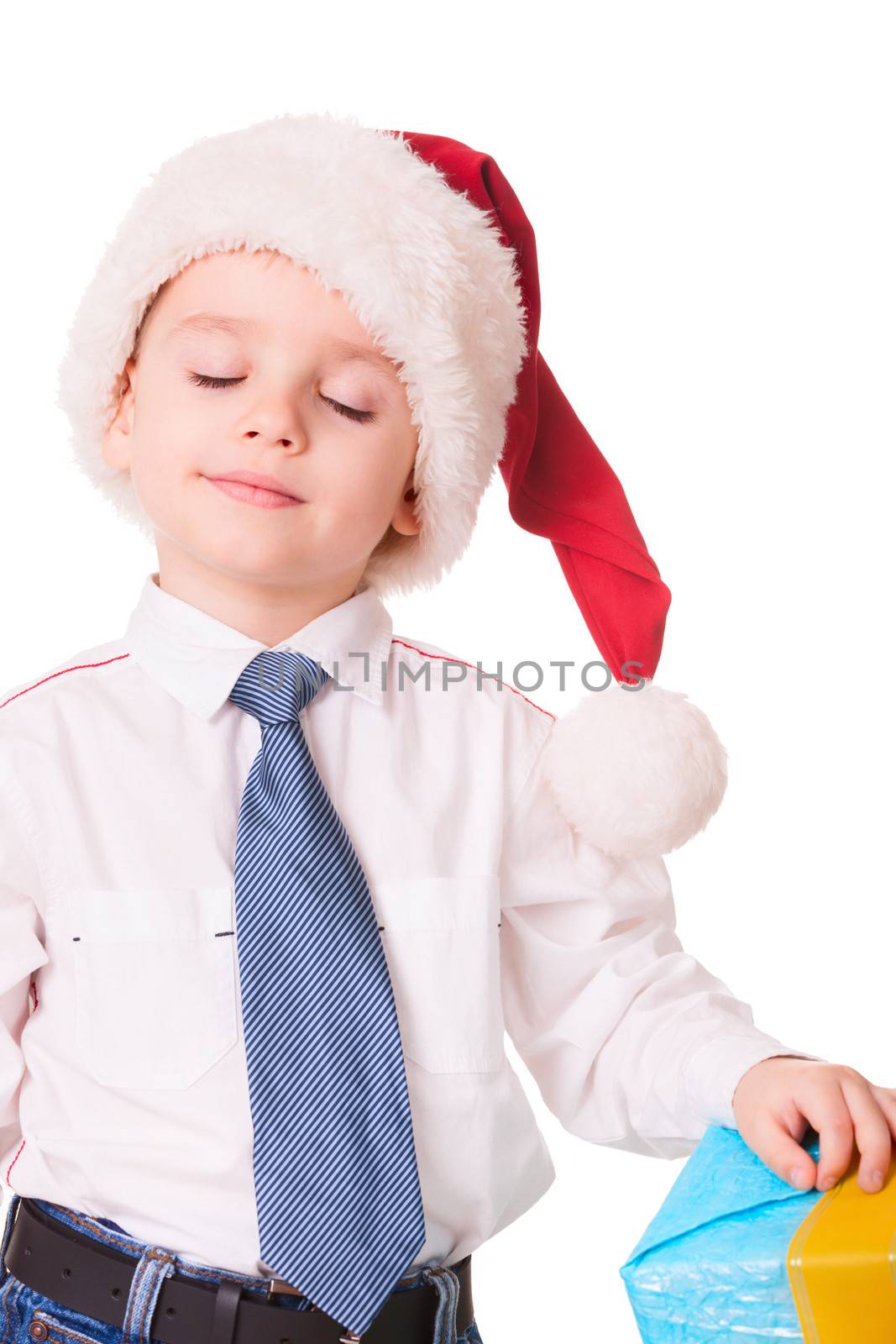 Little dreamy boy in Christmas red santa hat on white background