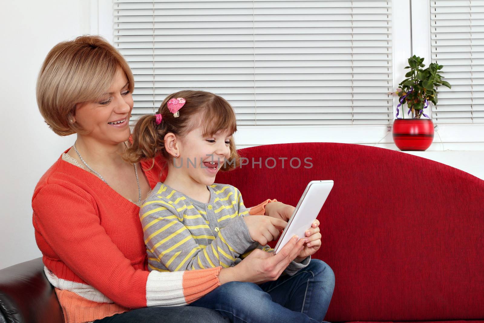 happy mother and daughter play with tablet pc by goce