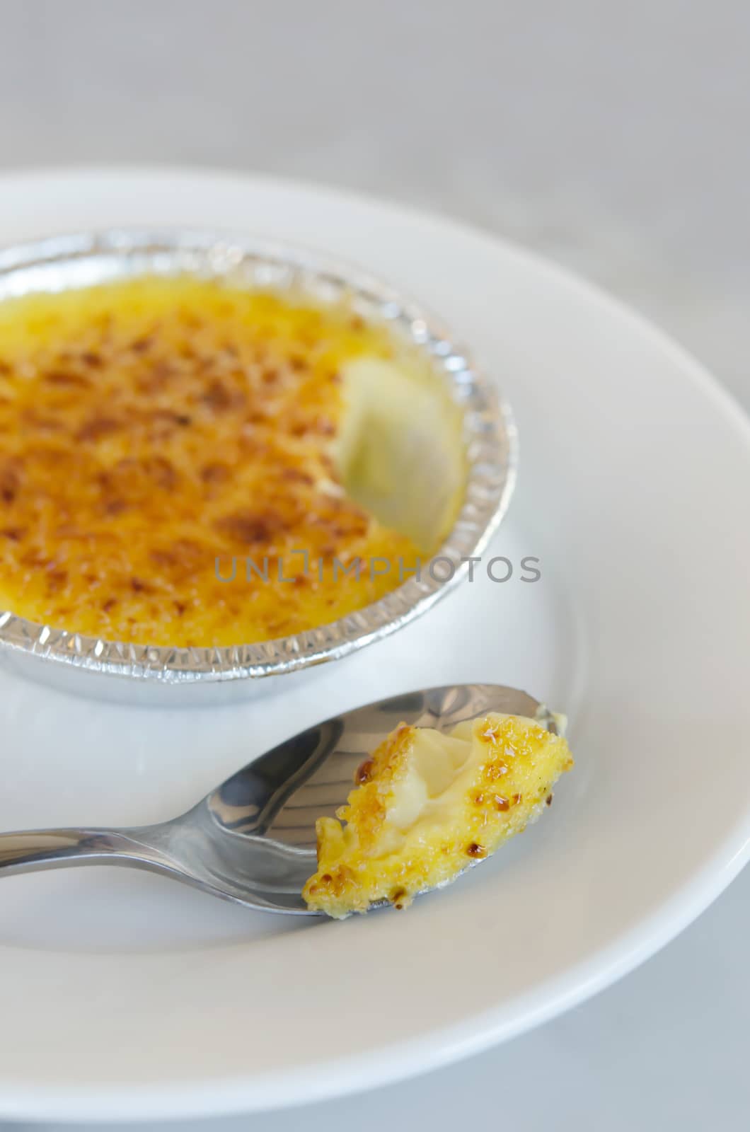 Sweet caramelized custard , French dessert - creme brulee with silver spoon over dish