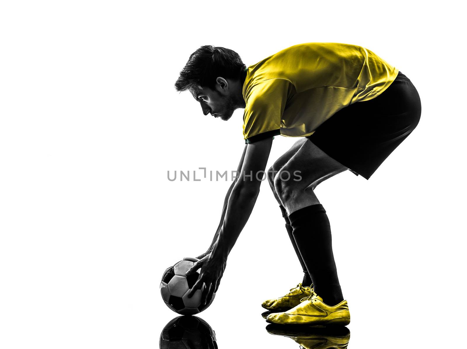 one brazilian soccer football player young man preparing free kick in silhouette studio  on white background
