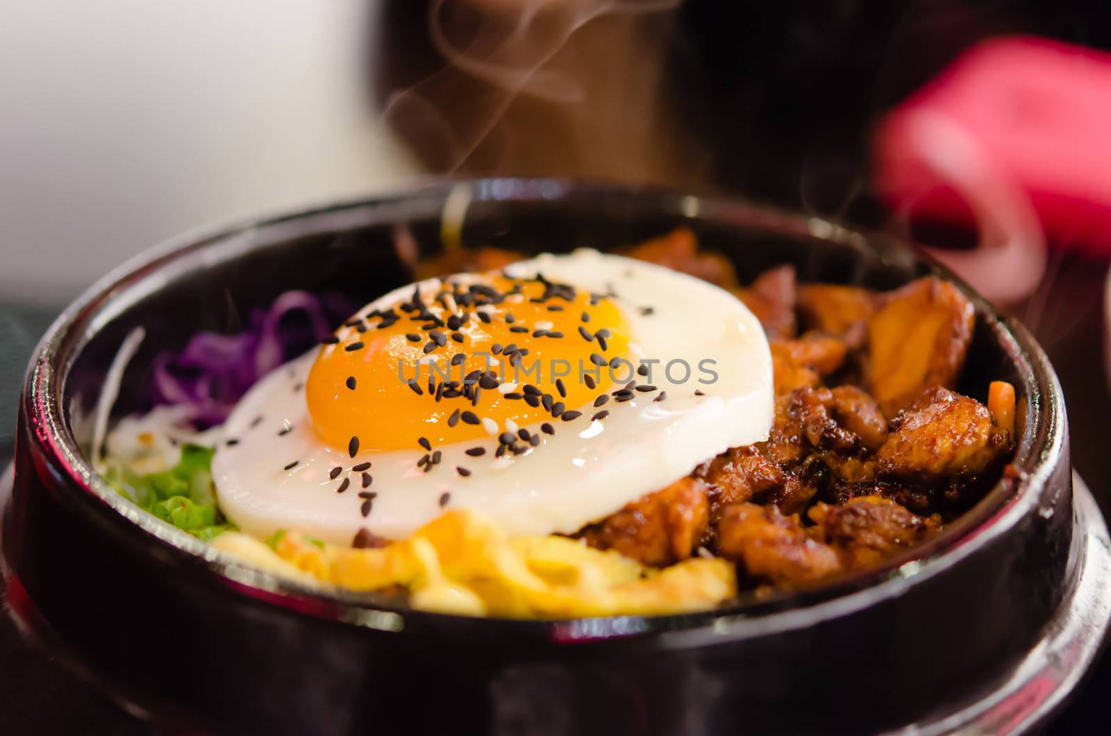 bibimbap in a heated stone bowl  ( rice with meat , mix vegetable and egg ) 