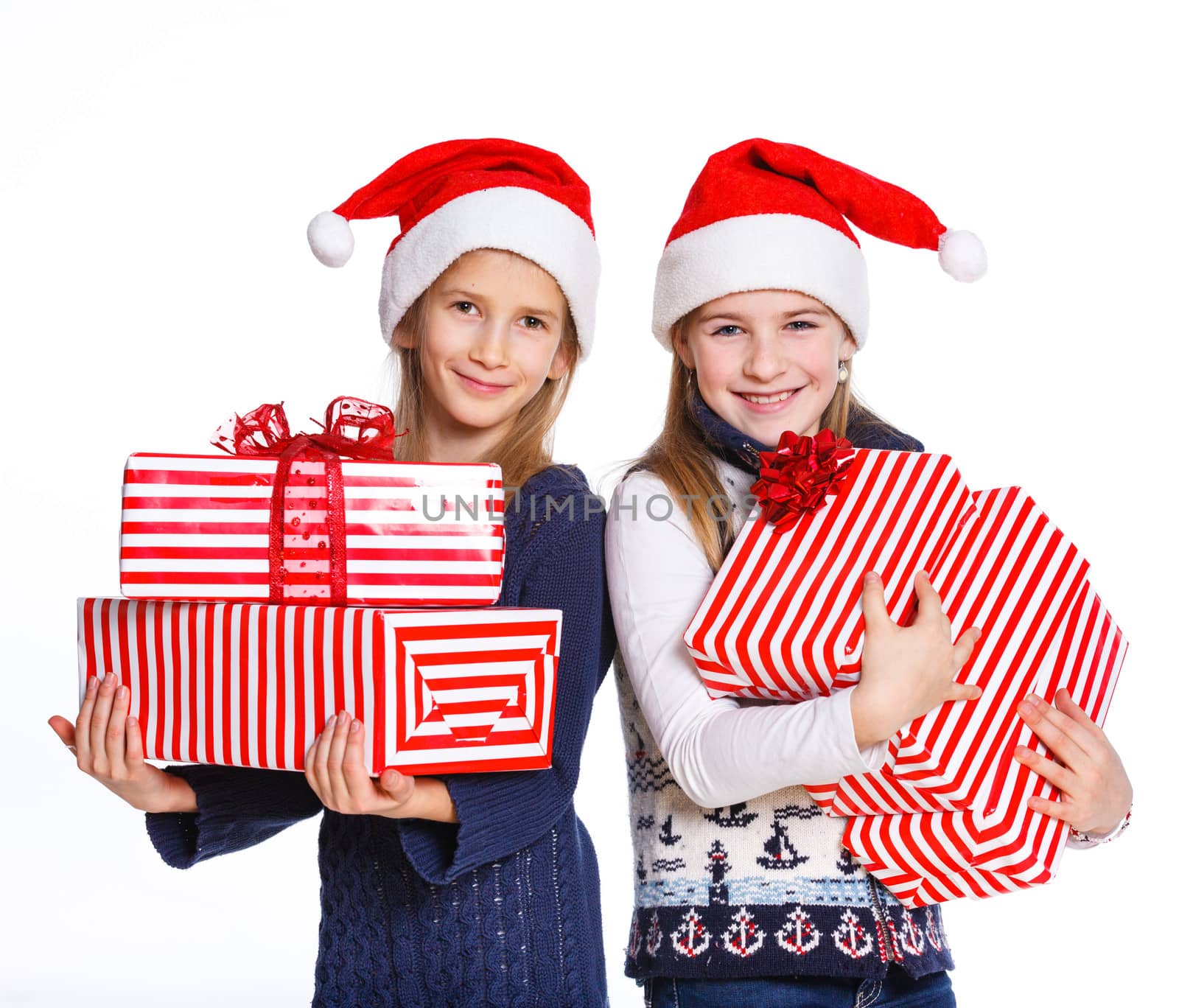 Christmas theme - Two smiling girl in Santa's hat with gift box, isolated on white