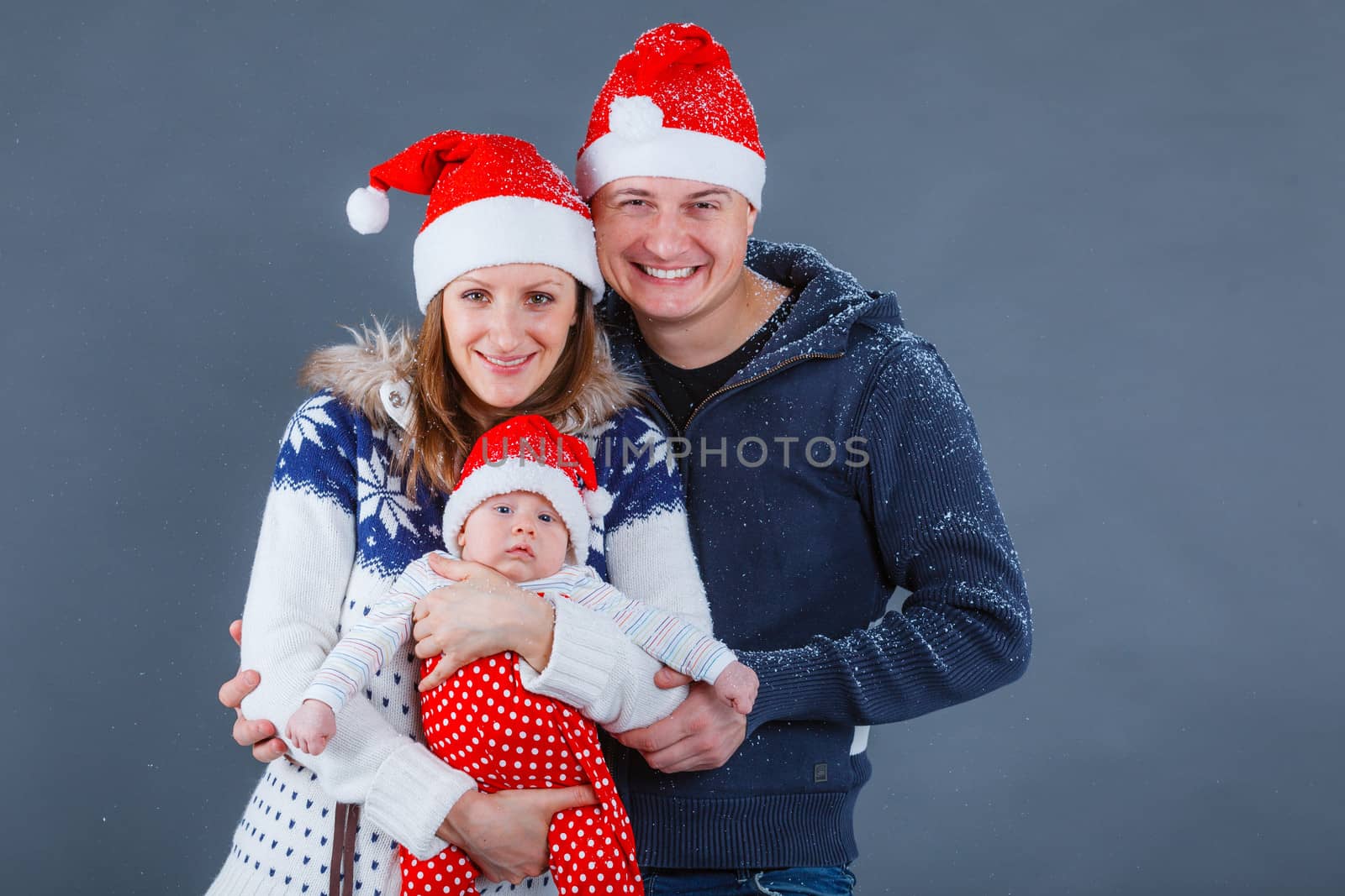 Christmas theme - Portrait of happy family with baby in Santa's hat in studio