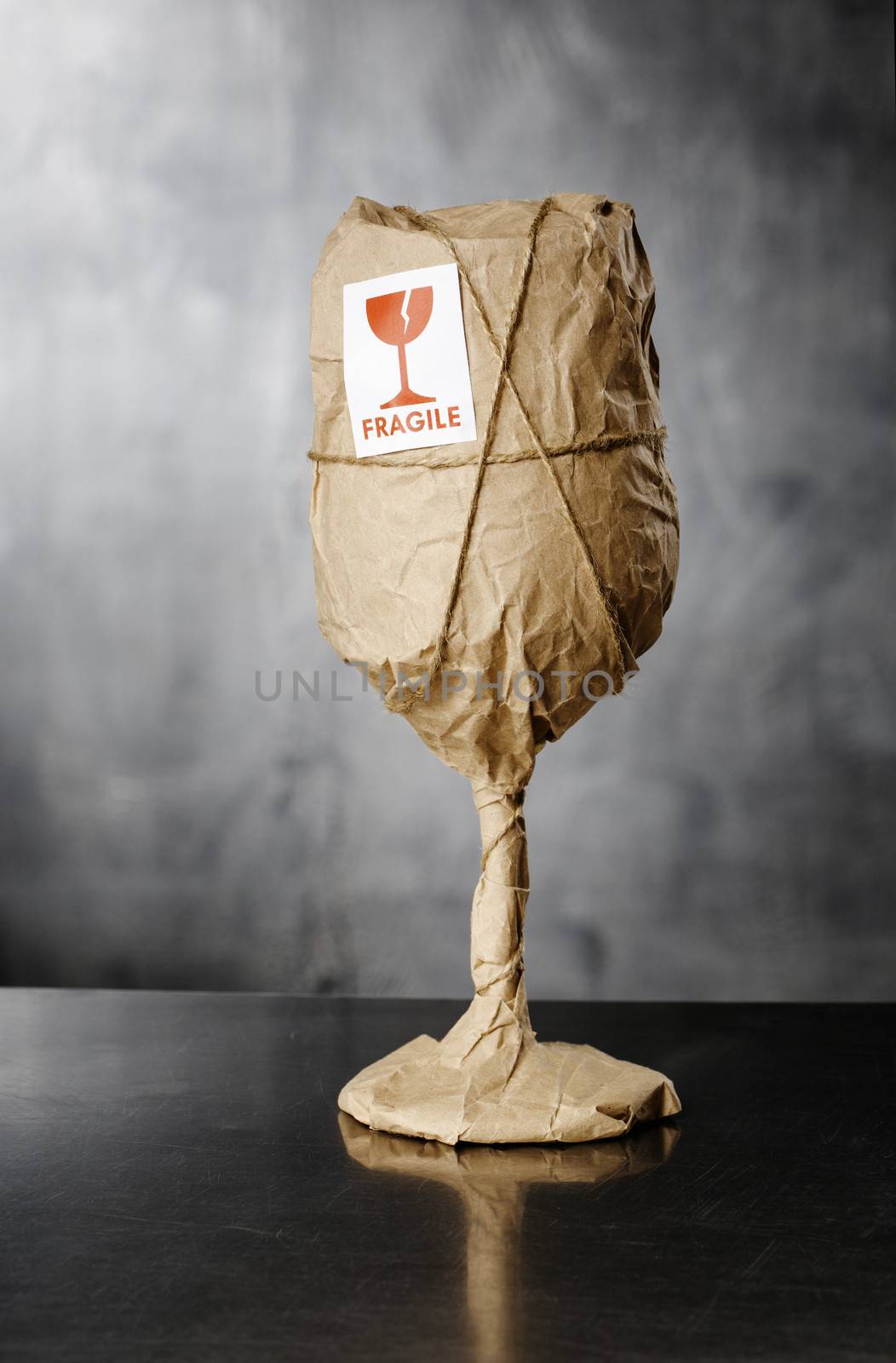 A Wine glass packaged in brown wrapping paper with "Fragile" warning sticker.