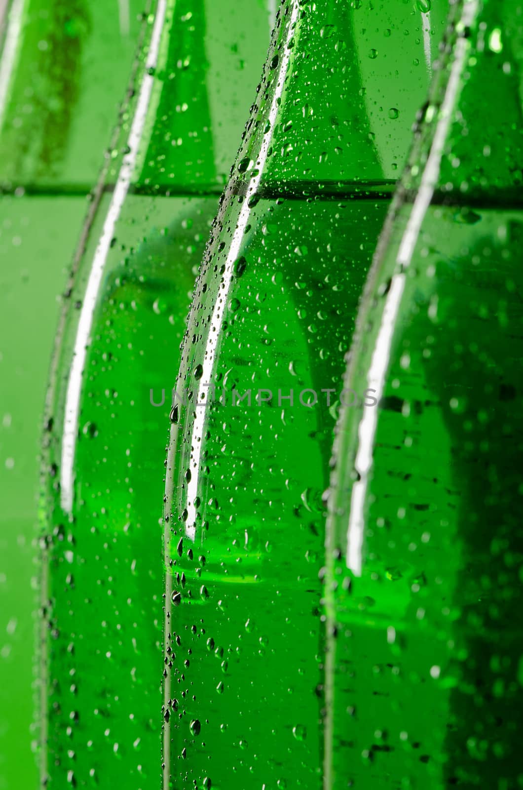 Green bottles of mineral water with water drops on it