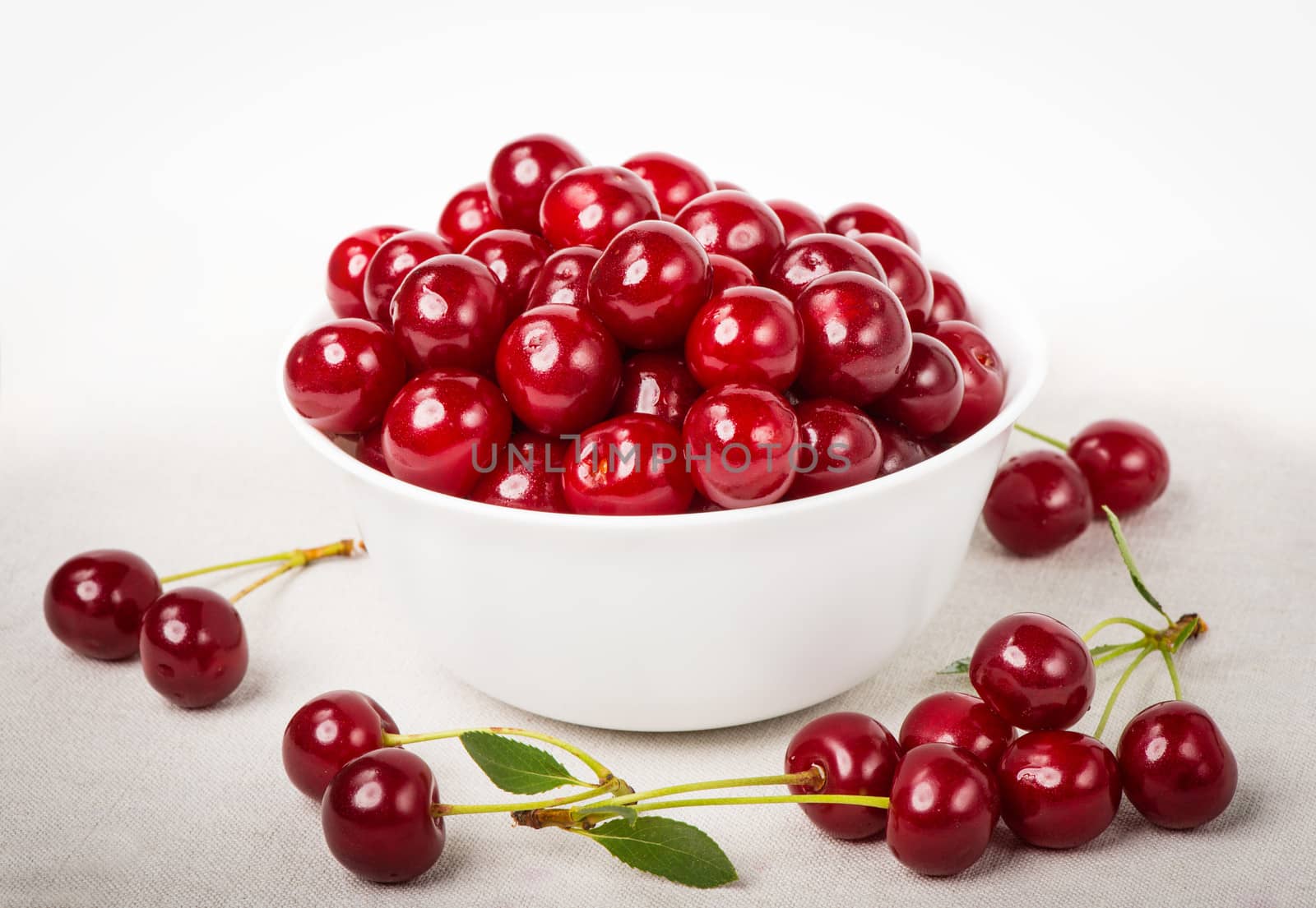 Sweet juicy cherries in a bowl on the napkin