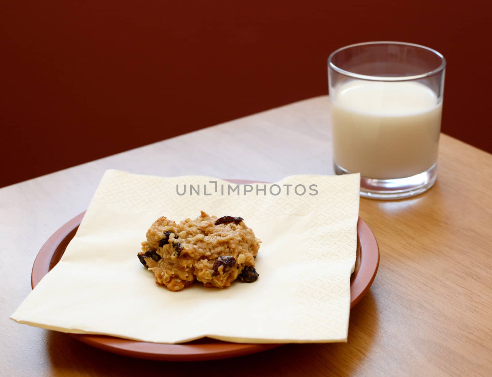 Fresh oatmeal raisin cookie served with a glass of cold milk