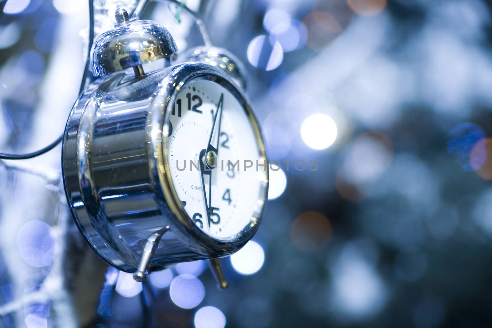 metal clock on a holiday background with sparkles and highlights by Serp