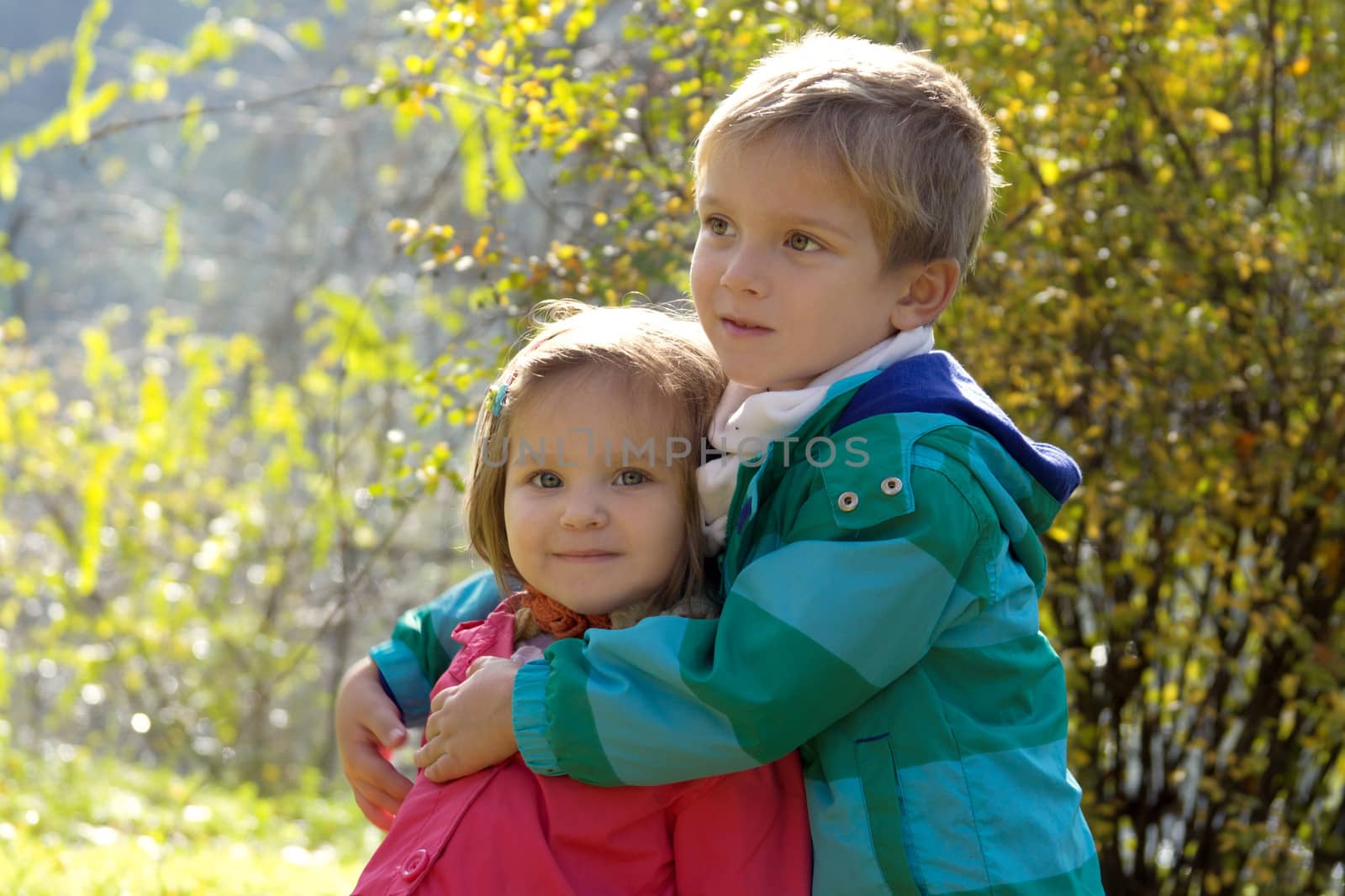 Brother hugging sister in autumn park by Angel_a