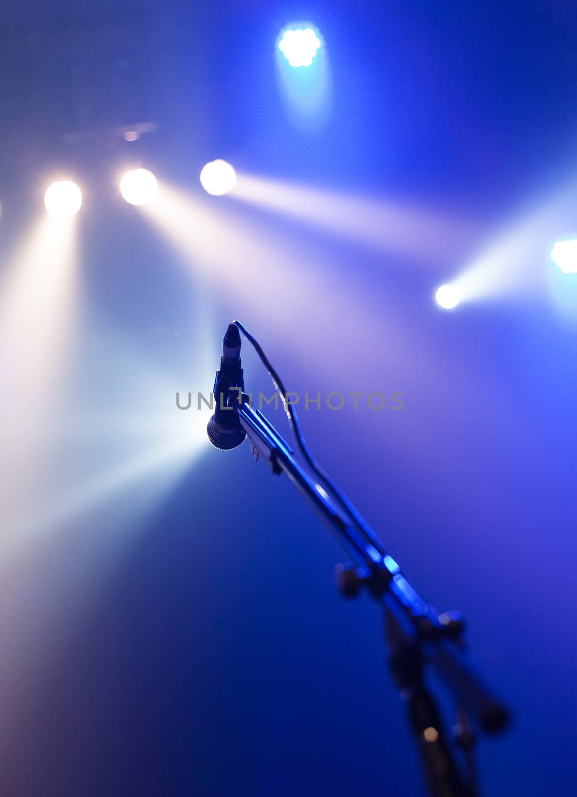 Microphone on empty stage waiting for a voice with copyspace and back light
