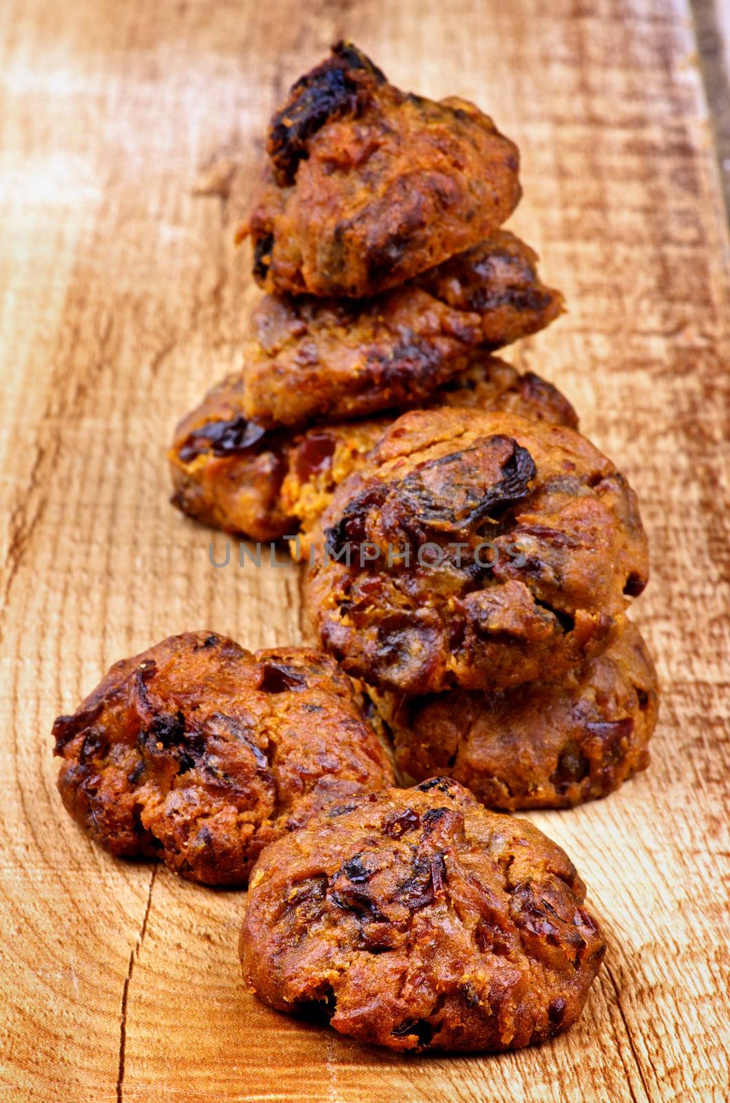 Heap of Delicious Cookies with Chocolate Chip and Raisins closeup on Wooden background