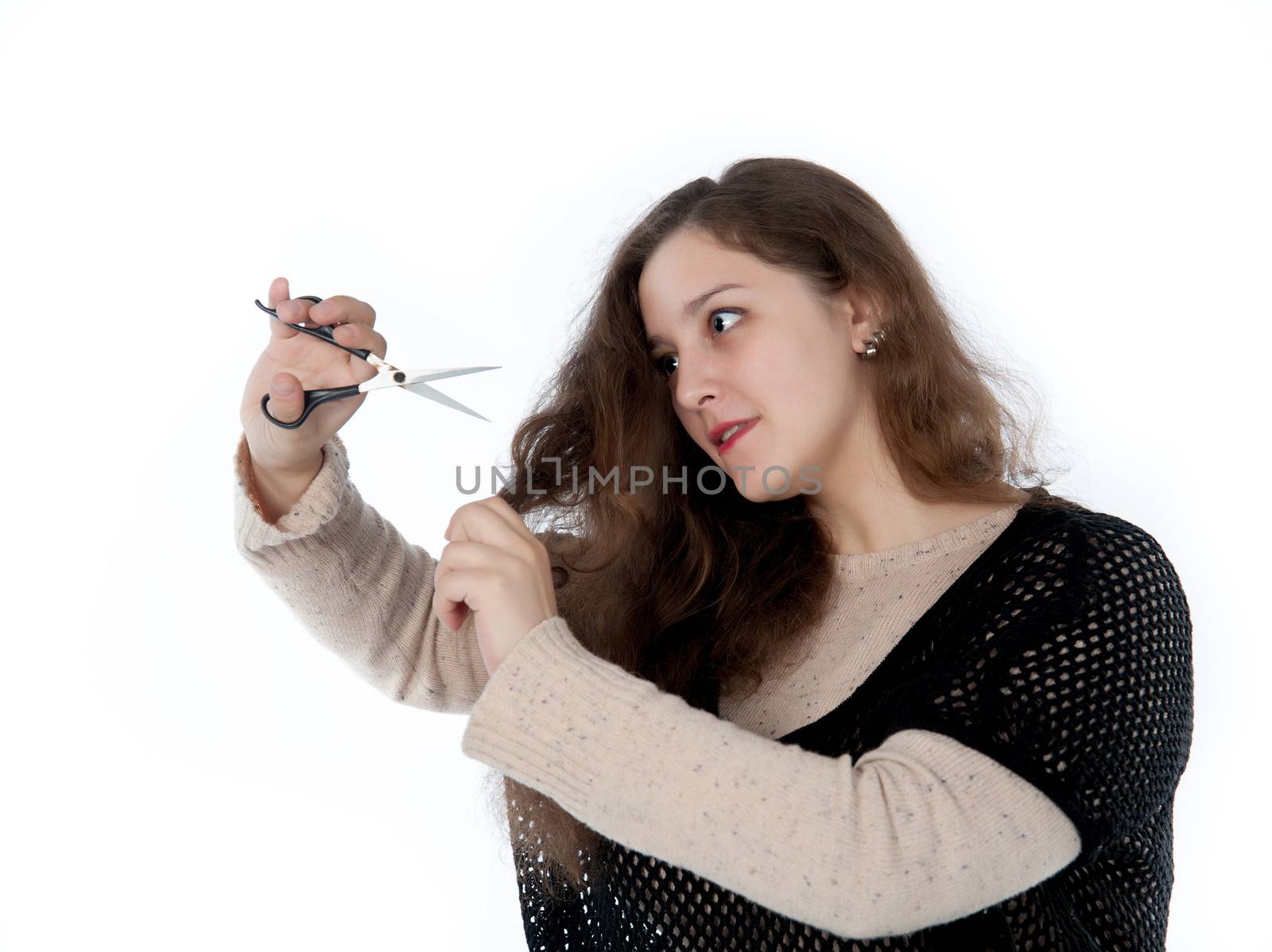 woman mows split ends of hair with scissors