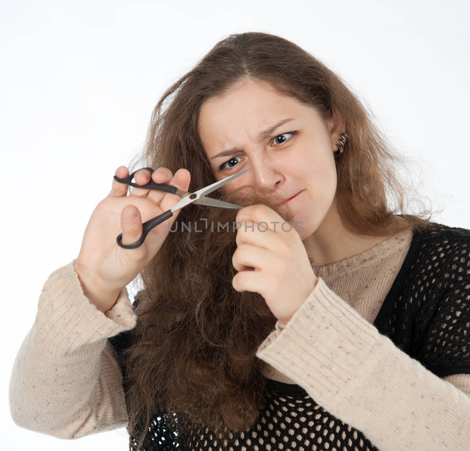 woman mows split ends of hair with scissors