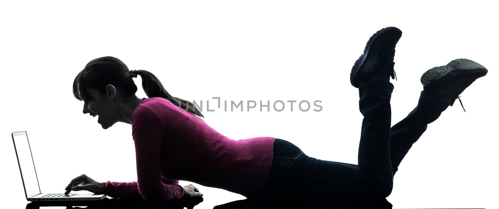 one caucasian woman laughing  computing laptop computer  in silhouette studio isolated on white background