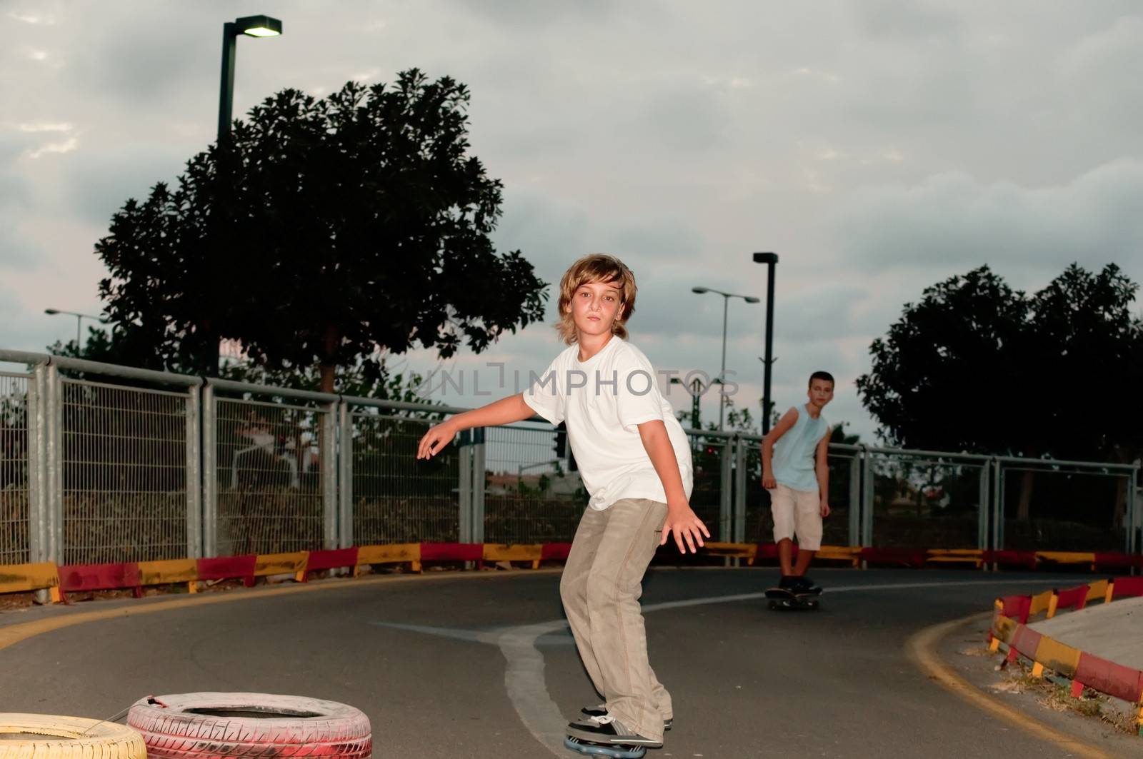 Teenage boys on skateboards in the evening the park.