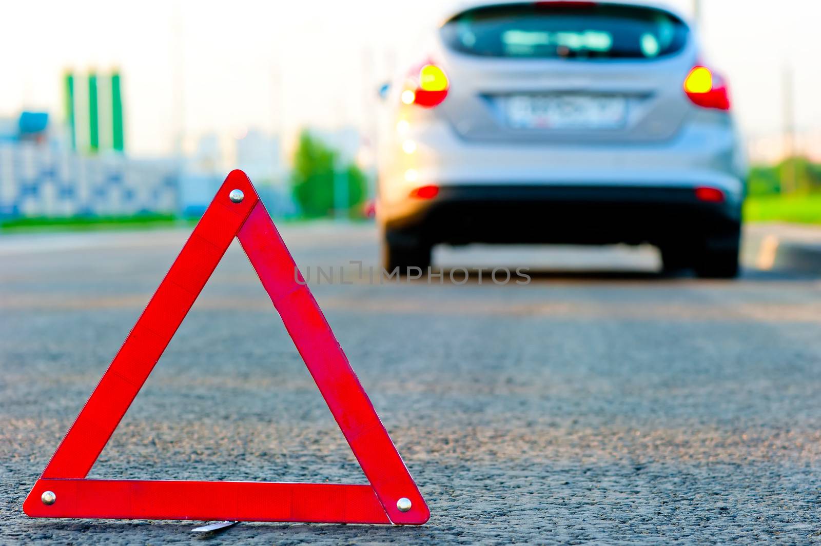 warning triangle on the road and the car moved down to the curb