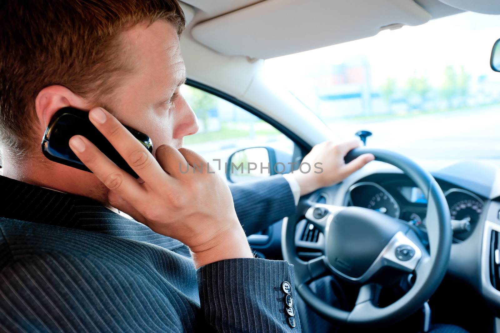 male businessman talking on a cell phone while driving by kosmsos111