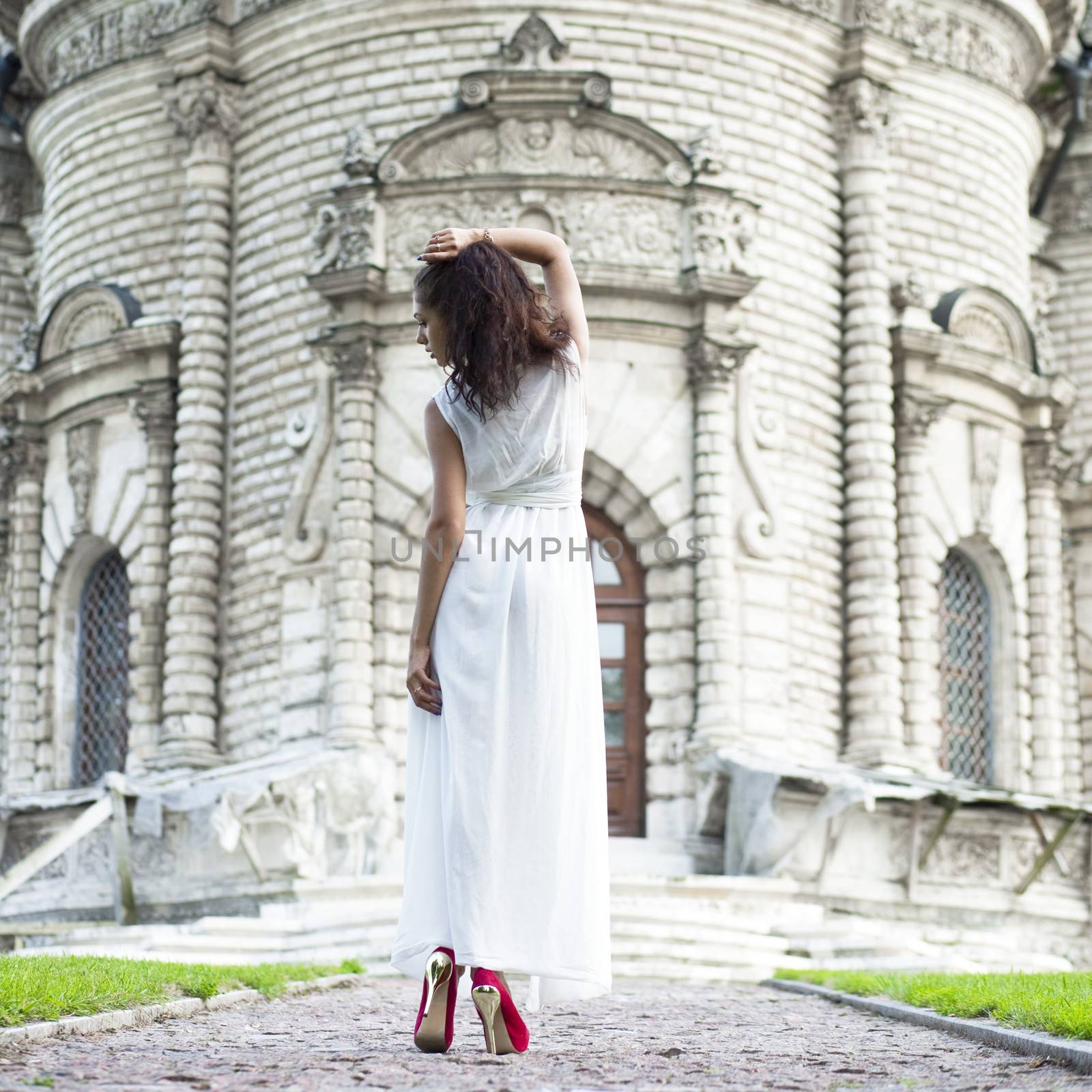 Sexy woman in a white dress on a background of the church