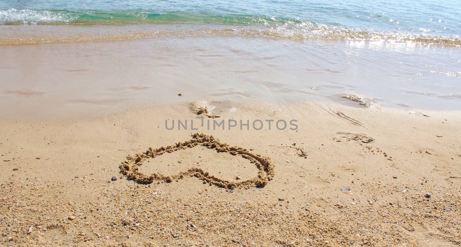 A eart drawn with sand on the beach