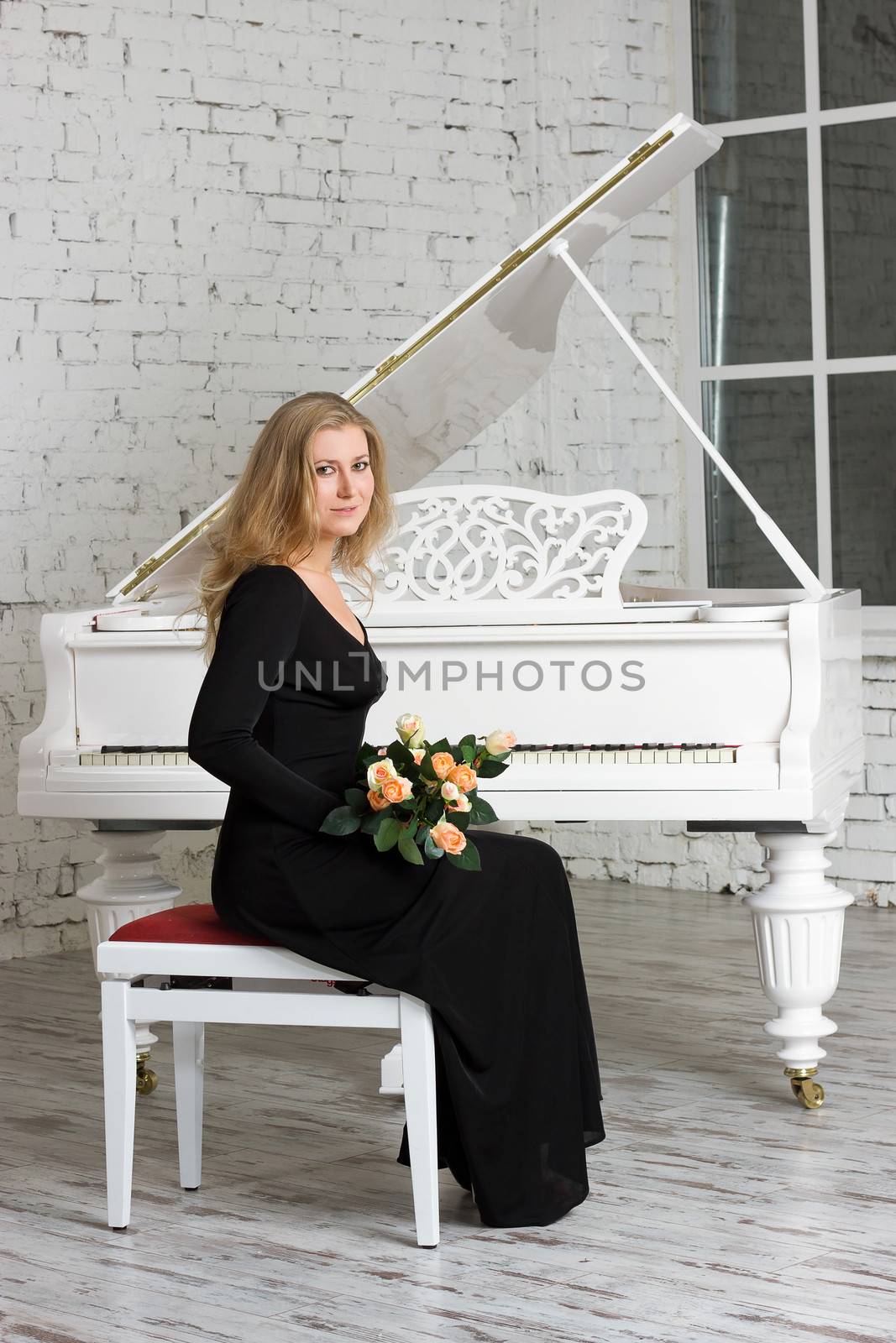 beautiful young woman playing the white piano