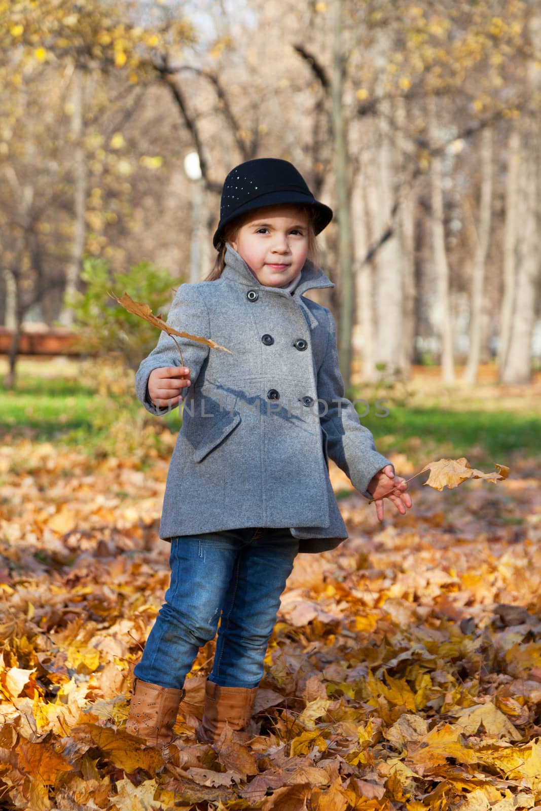 little girl in a coat walks in autumn park by elena_shchipkova