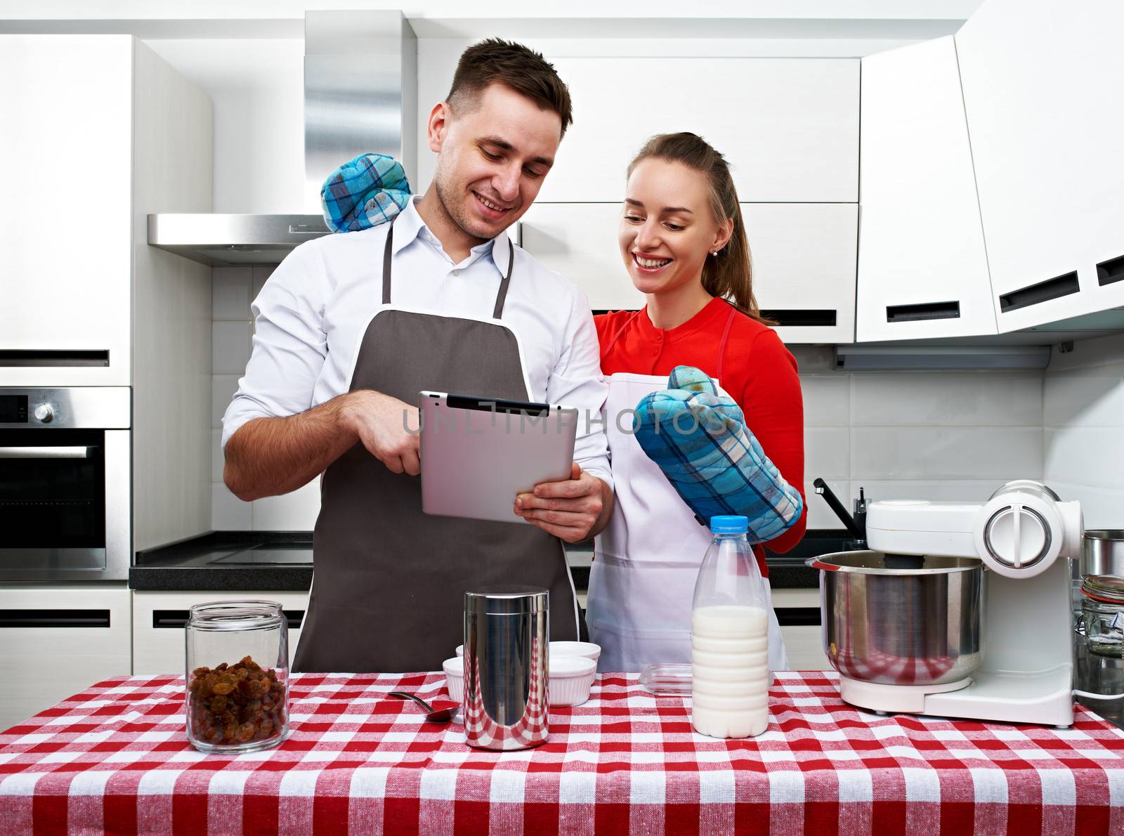 Couple at kitchen with tablet pc by haveseen