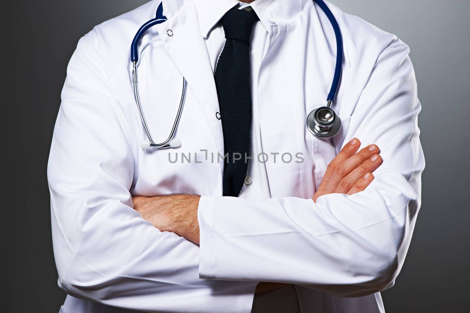 Medical doctor with stethoscope portrait against grey background 