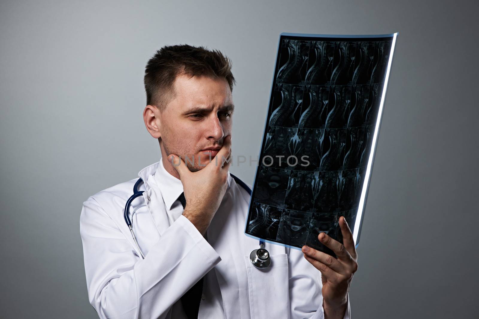 Medical doctor with MRI spinal scan portrait against grey background 