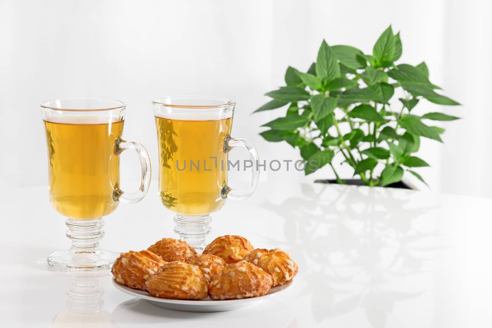 Tea in glass cups, tasty cookies and green mint.