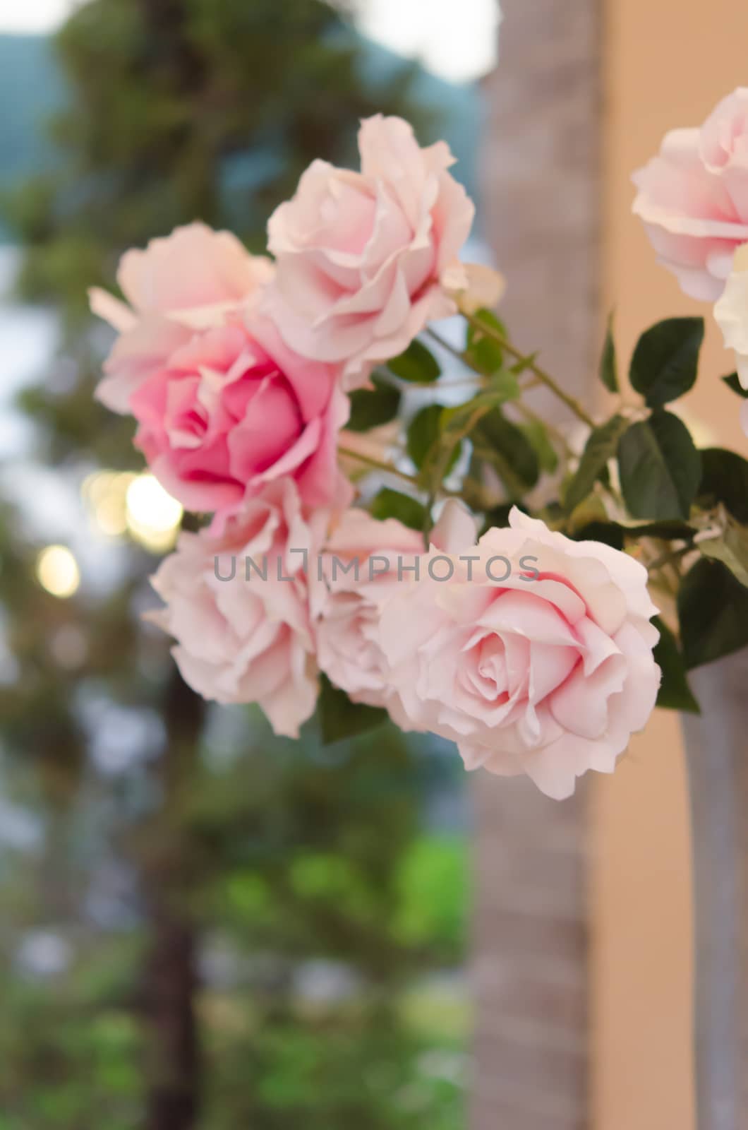 close up bouquet of plastic  pink roses  with green leaves