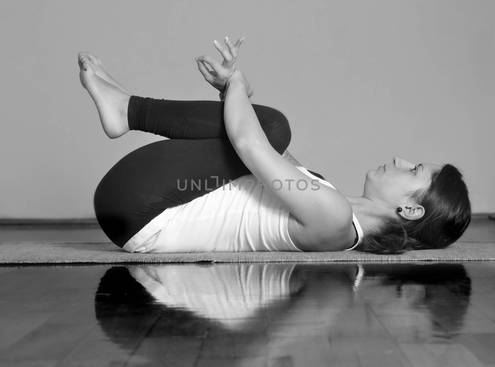 Girl doing Apanasana yoga pose by anderm