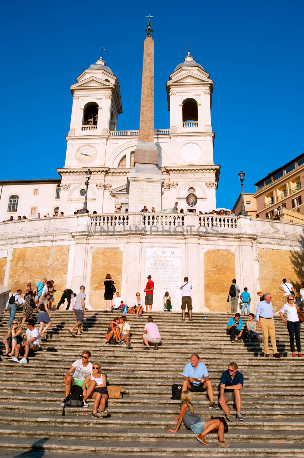 Rome, Italy -  September 27, 2013: Crowd sitting on the Spanish Steps onin Rome, Italy. With 138 steps in total, the Spanish Steps of Rome are the longest and widest outdoor steps in Europe.