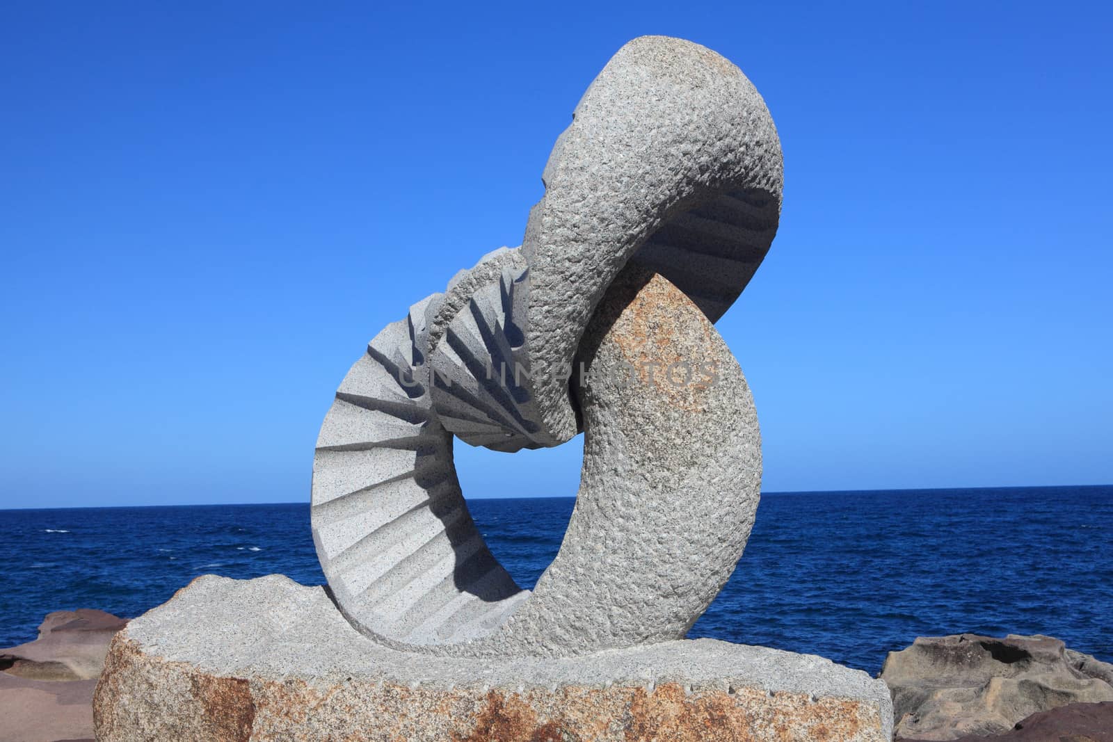 BONDI BEACH, AUSTRALIA - OCTOBER 30, 2013: Sculpture By The Sea, Bondi 2013. Annual event that showcases artists from around the world  Sculpture titled 'Oushi zokei 2 rings' by Keizo Ushio (Japan).  Medium blue granite, brown granite, Price $135,000
