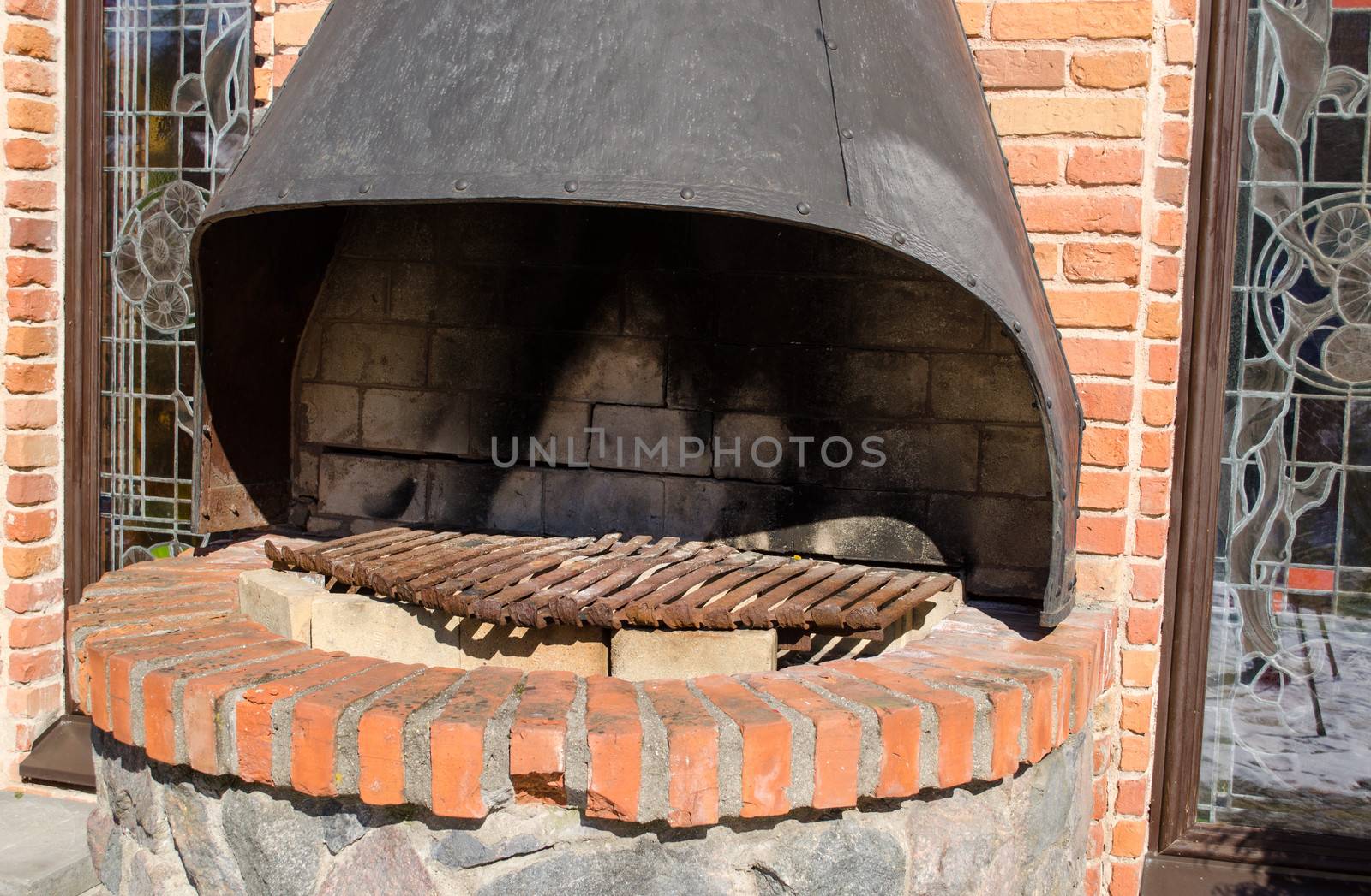 closeup of outdoor retro brick hearth fireplace in restaurant building wall.