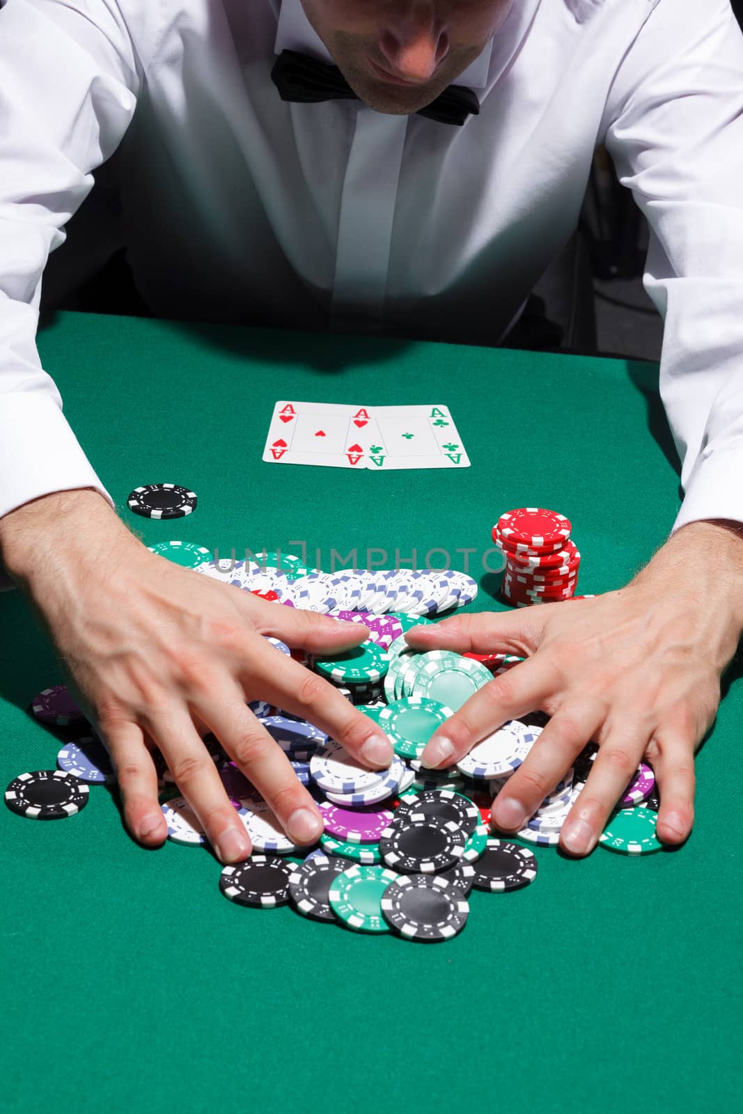 Gentleman in white shirt, playing cards, on black background