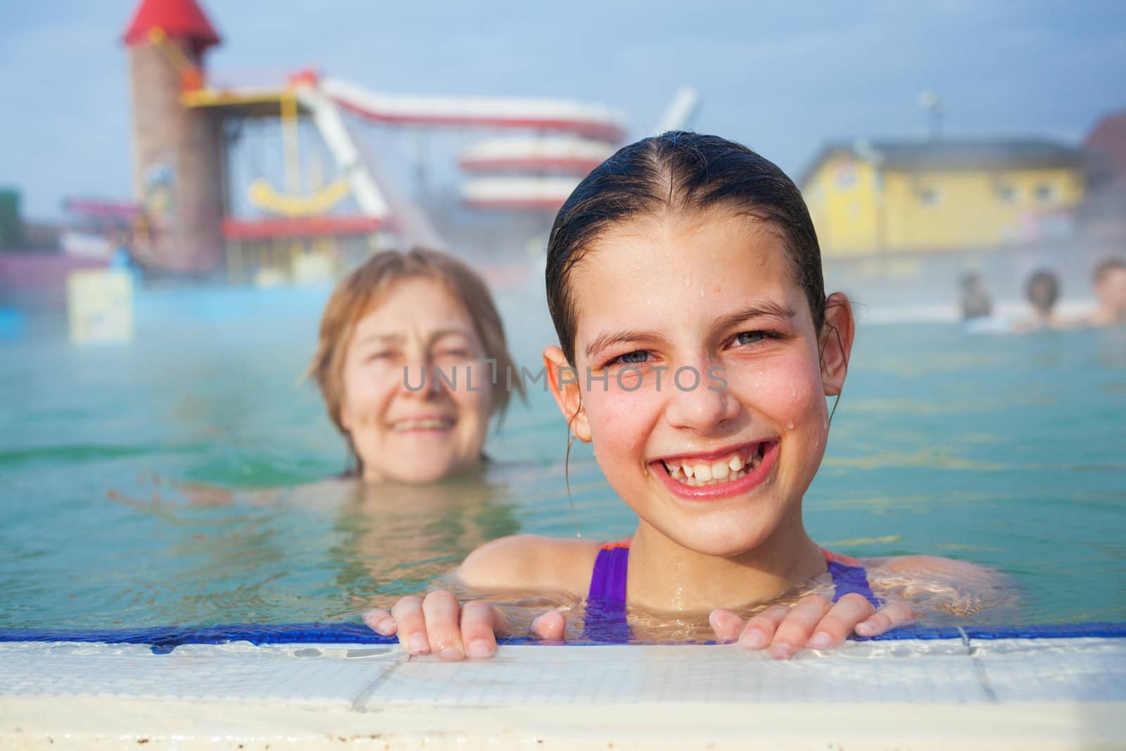 Activities on the pool. Portrait of cute girl with grandmother relaxing in termal swimming pool