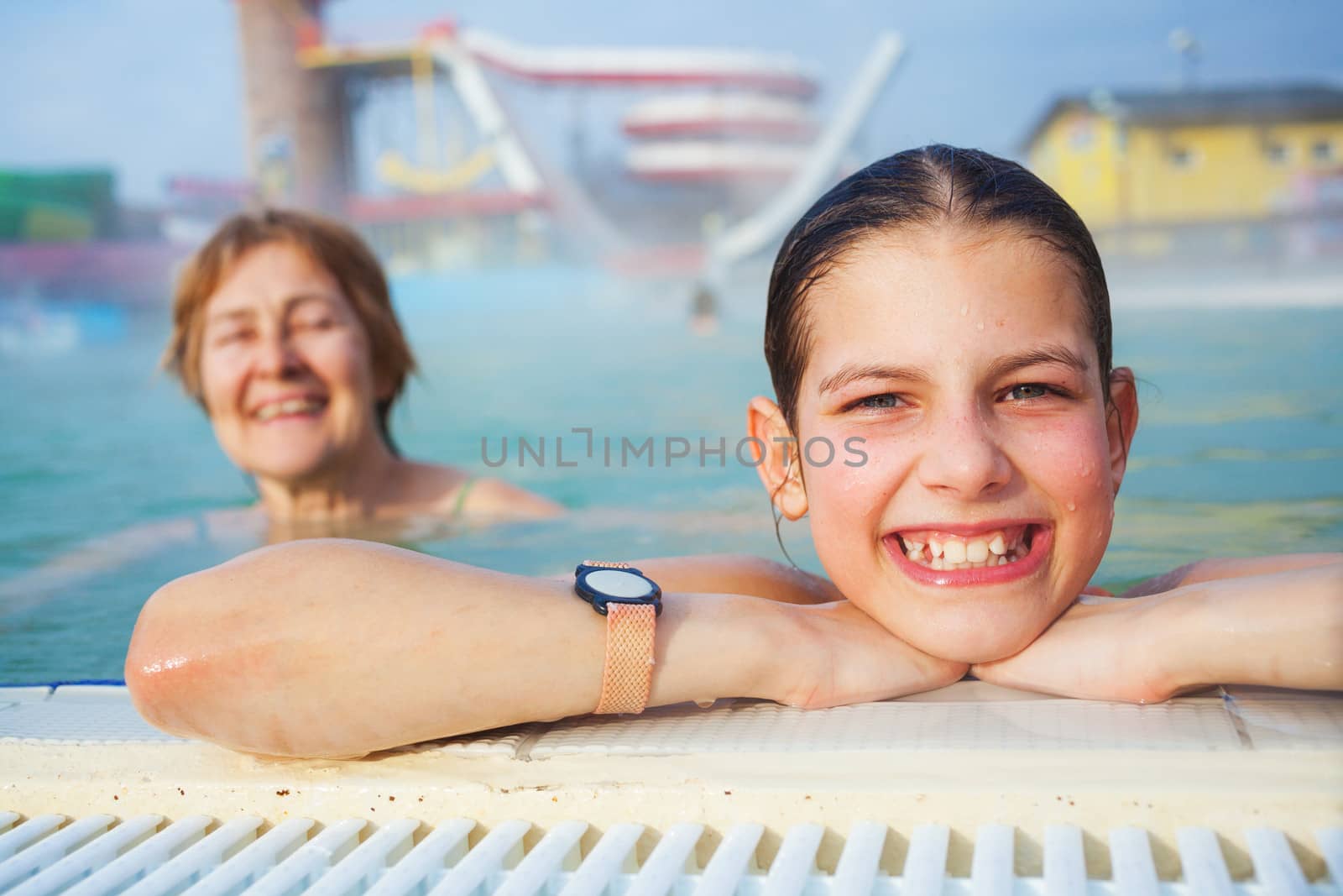 Activities on the pool. Portrait of cute girl with grandmother relaxing in termal swimming pool