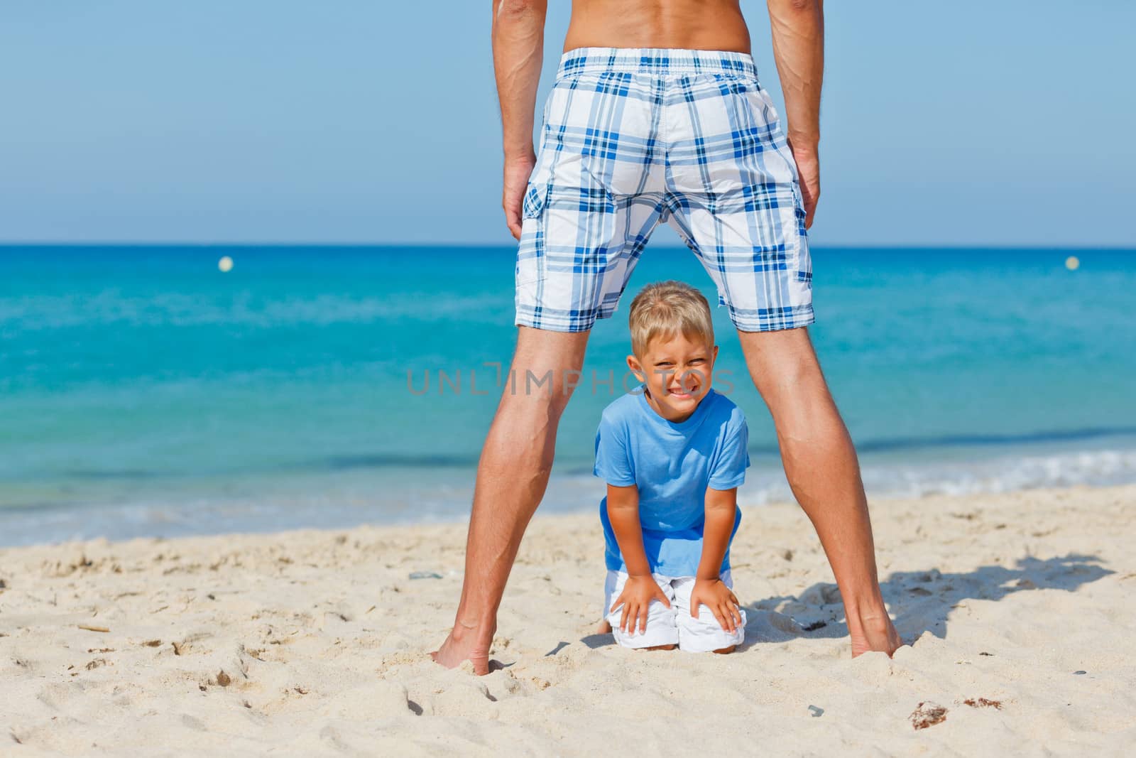 Father and son relaxing on beach holiday