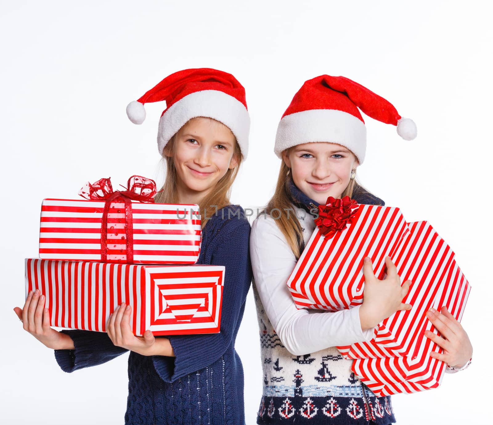 Christmas theme - Two smiling girl in Santa's hat with gift box, isolated on white