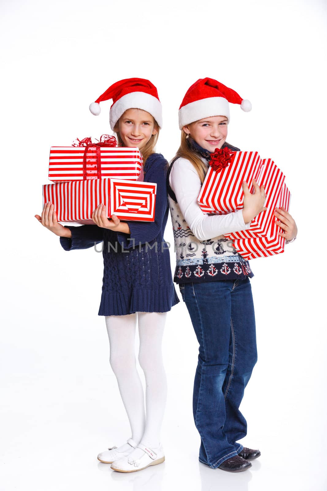 Christmas theme - Two smiling girl in Santa's hat with gift box, isolated on white