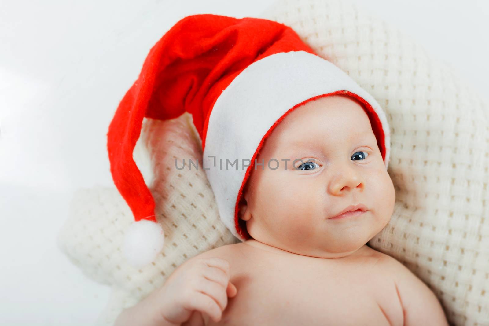Christmas theme. Portrait of baby boy in a Santa hat in studio