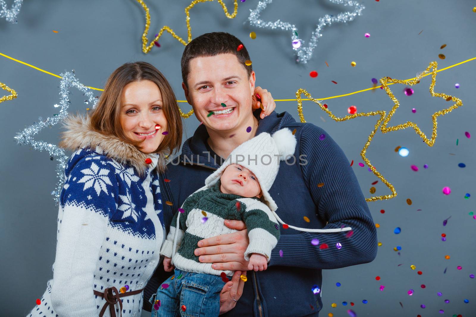 Christmas theme - Portrait of happy family with baby in winter clothing in studio