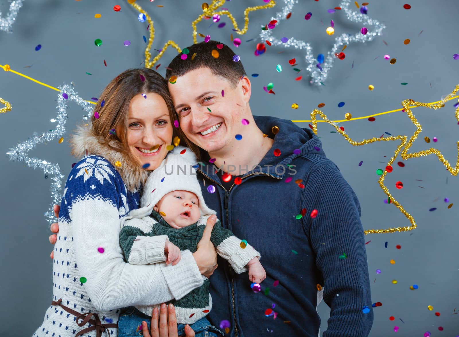 Christmas theme - Portrait of happy family with baby in winter clothing in studio