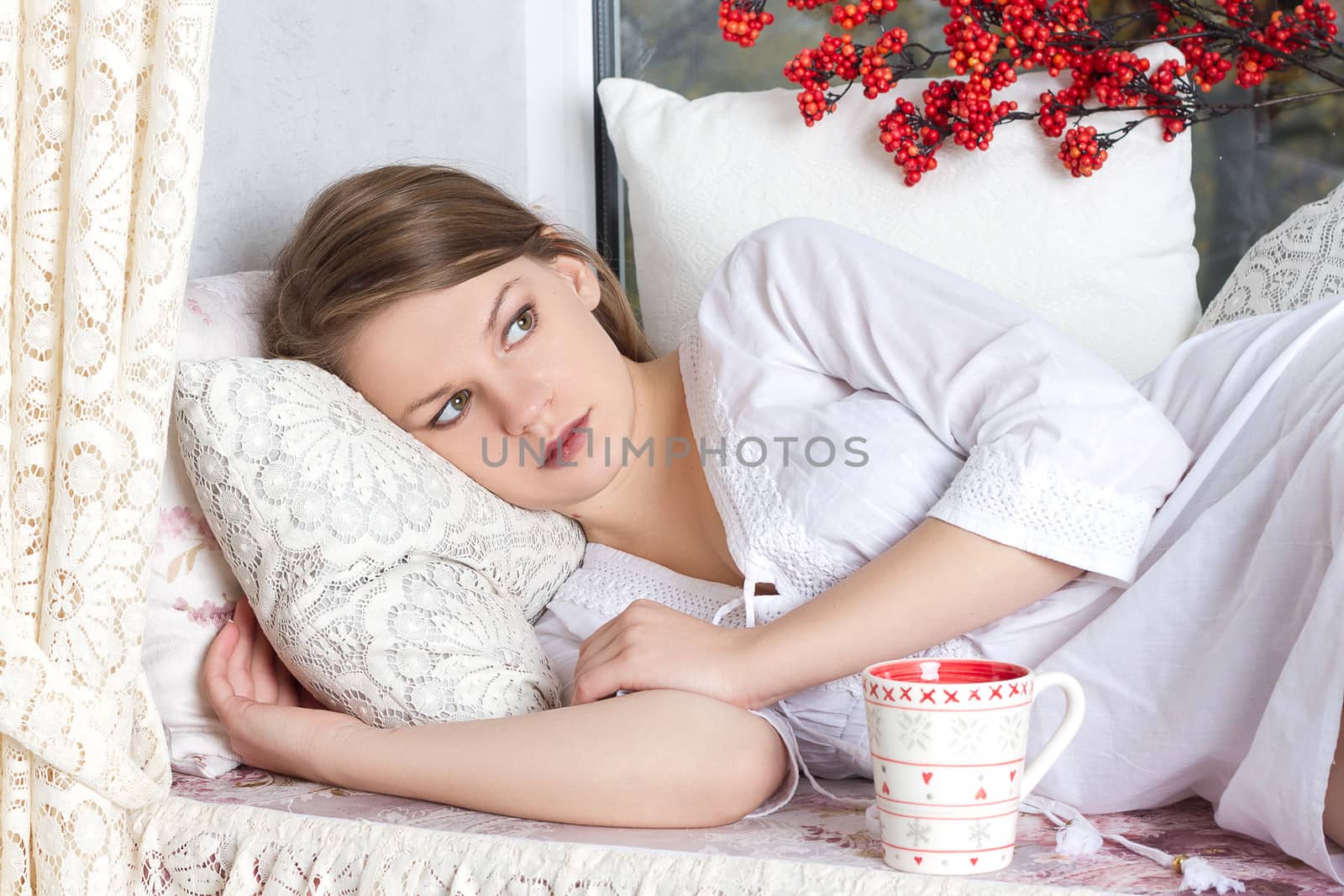 beautiful blond woman awaking with cup of coffee at bedroom