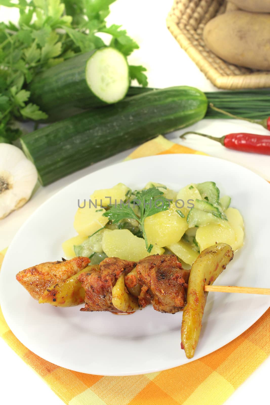 Potato-cucumber salad with fire skewers on a light background